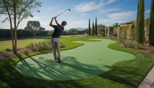 A golfer practicing on a custom synthetic golf green in a landscaped backyard.